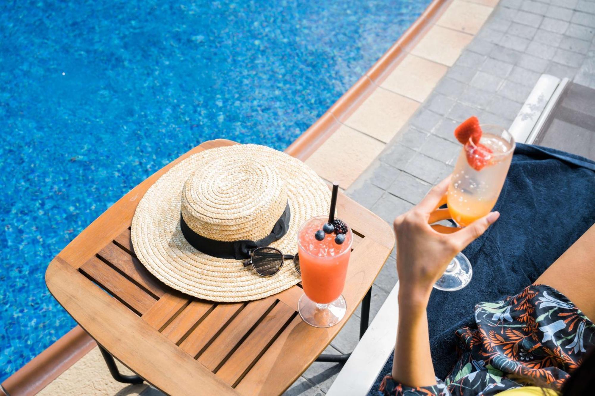 Hotel Hilton Ad Dawhah Esterno foto A woman holding a cocktail